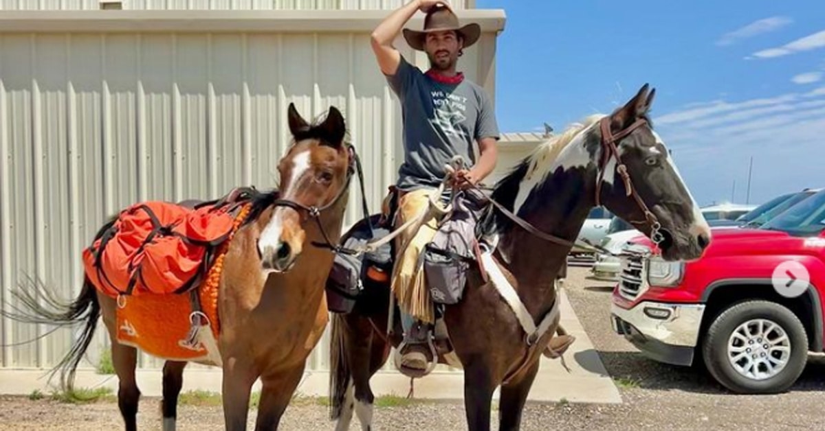 A man sitting on a paint horse and holding a bay.