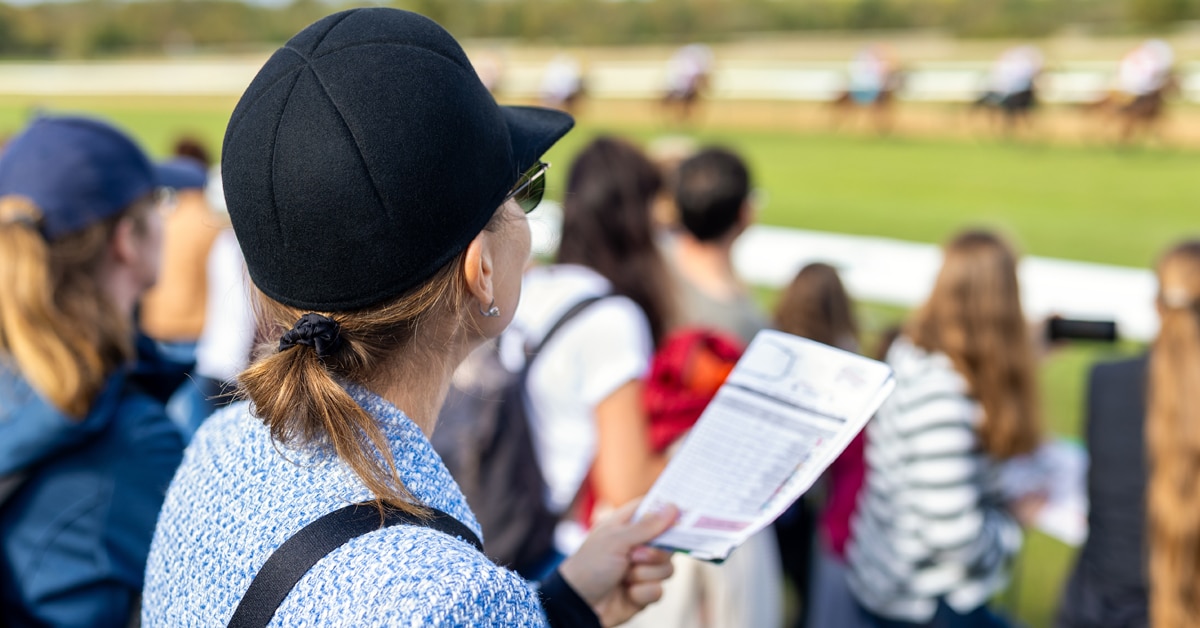 A crowd of people watching a horse race.